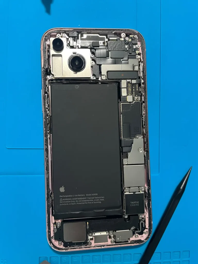 iPhone opened up on the repair bench showing the battery and internal parts
