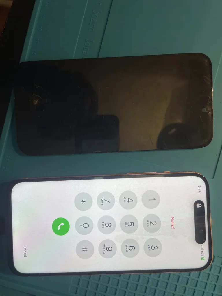 iPhone next to a replacement screen before installation