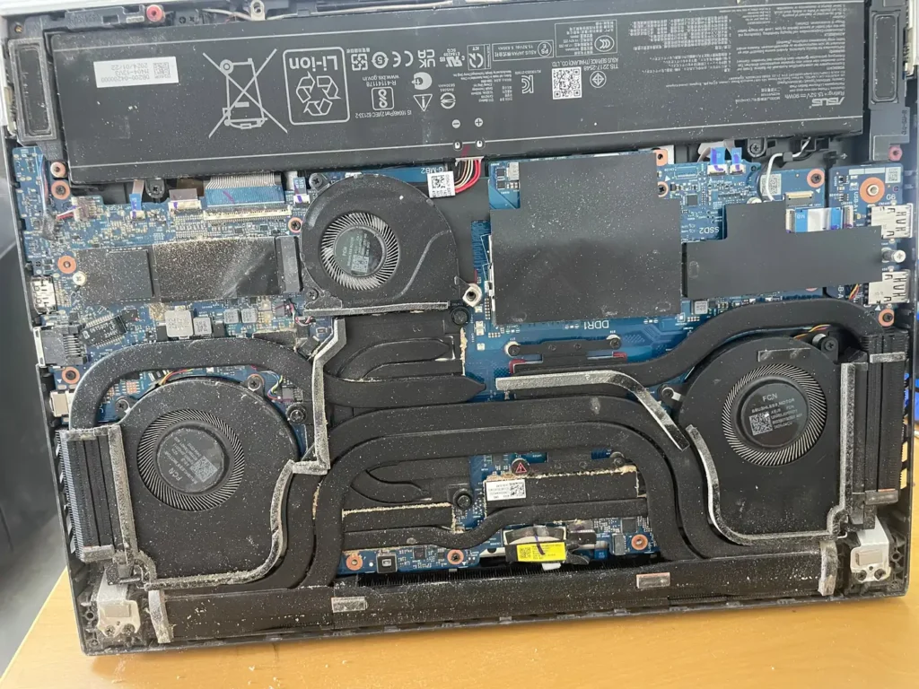 Laptop with the bottom cover removed showing fans and internals