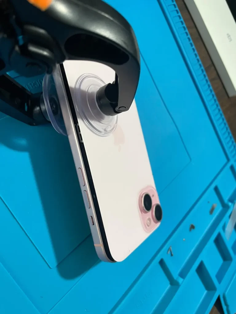 iPhone back glass held in a repair clamp