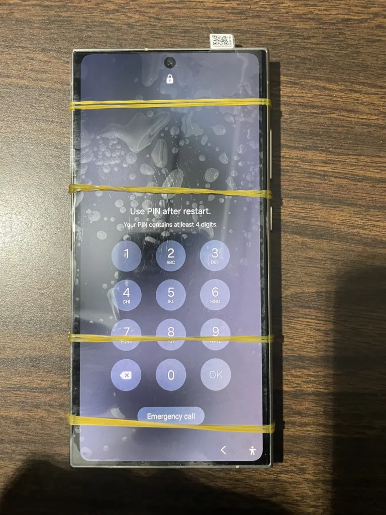 Phone with a taped cracked screen waiting for data recovery